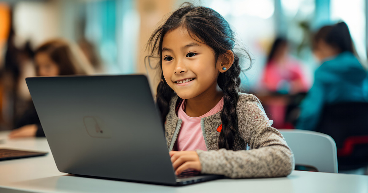 A VisionX Coders student coding on her laptop in class